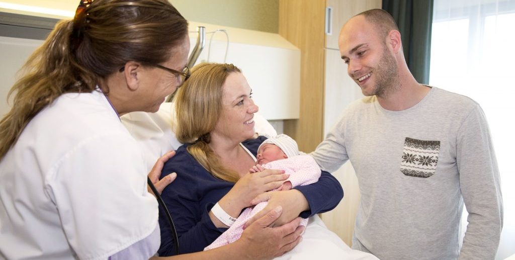 Samen zwanger ouders met baby en verpleegkundige